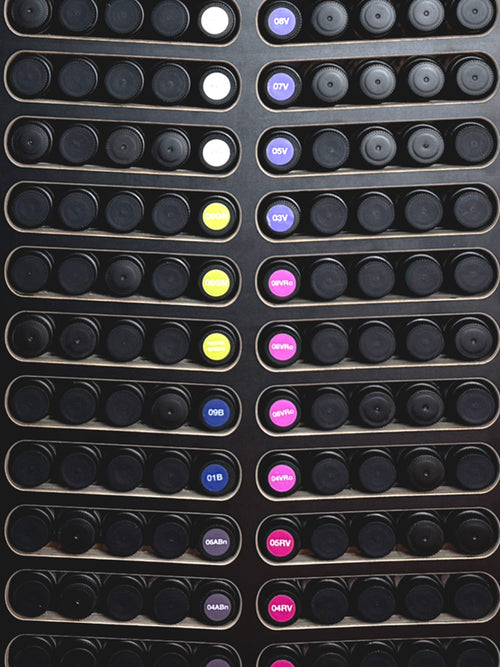 Colorful Labels on Black cabinet for Shades EQ hair color bottles to identify and organize for salons