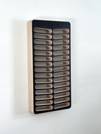 Wall-mounted hair dye organizer with multiple compartments on a white background