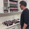 A salon owner watching their har dye bottles pour out of their dispensary's cabinet because their color bar has no hair color bottle organizer.